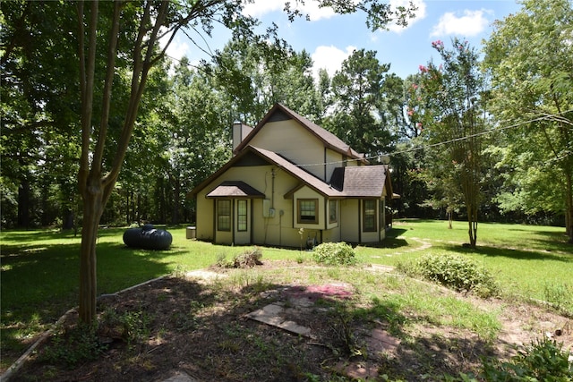 191 Harvey Bryant Rd, Coldspring, TX 77331 - view of home's exterior with a chimney, a lawn, and view of scattered trees