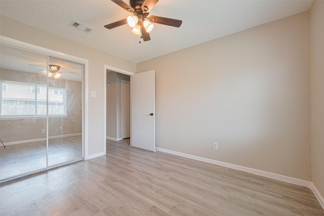 6822 Stonewater, Houston, TX 77084 - unfurnished bedroom with light wood-style floors, a textured ceiling, a ceiling fan, and a closet