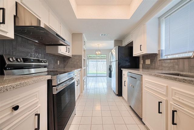 6822 Stonewater, Houston, TX 77084 - kitchen featuring stainless steel appliances, under cabinet range hood, light tile patterned floors, and backsplash