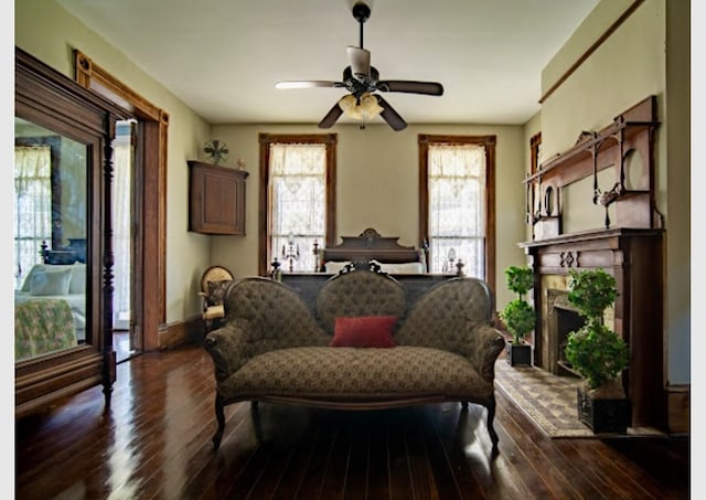 2113 Ball, Galveston, TX 77550 - sitting room with dark wood finished floors, a ceiling fan, and a fireplace with raised hearth