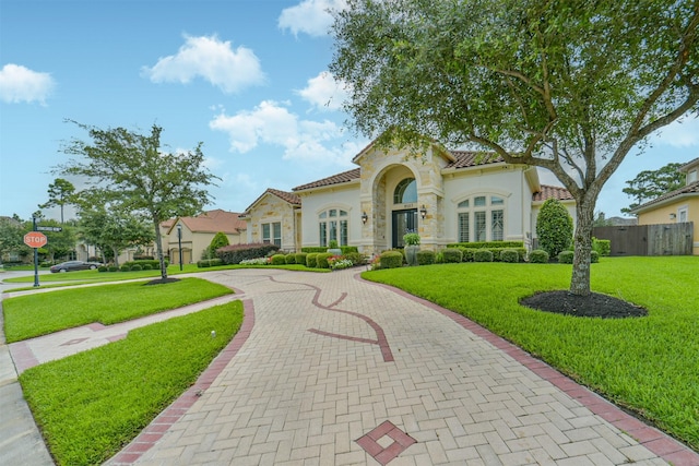 9503 Martha Springs Dr, Houston, TX 77070 - mediterranean / spanish-style house with decorative driveway, a tile roof, stucco siding, and stone siding