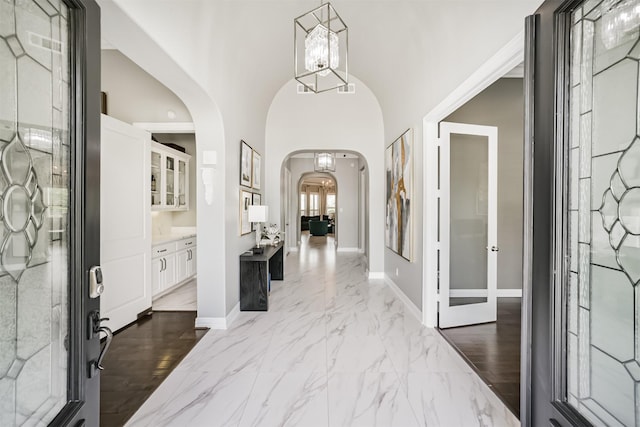 9503 Martha Springs Dr, Houston, TX 77070 - entrance foyer with arched walkways, a chandelier, and marble finish flooring