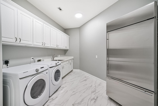 9503 Martha Springs Dr, Houston, TX 77070 - laundry room featuring washing machine and dryer, light marble finish floors, and cabinet space