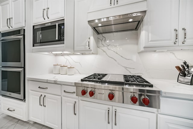 9503 Martha Springs Dr, Houston, TX 77070 - kitchen featuring appliances with stainless steel finishes, exhaust hood, white cabinetry, and tasteful backsplash