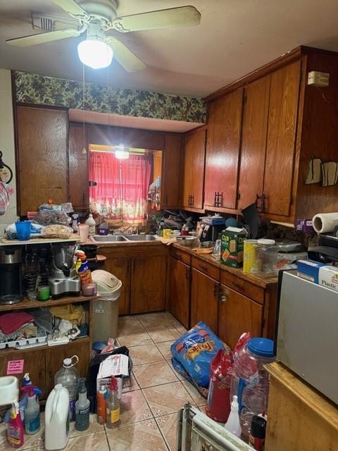4514 Kress St, Houston, TX 77026 - kitchen featuring brown cabinetry, ceiling fan, and light tile patterned floors