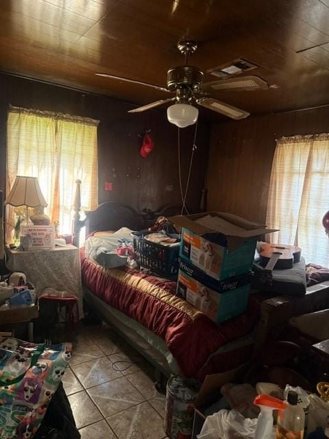 4514 Kress St, Houston, TX 77026 - bedroom with light tile patterned floors, wooden walls, and a ceiling fan