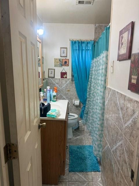 4514 Kress St, Houston, TX 77026 - bathroom featuring tile walls, vanity, tile patterned flooring, a shower with shower curtain, and wainscoting