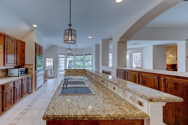 3910 Sand Myrtle Dr, Houston, TX 77059 - kitchen with stainless steel microwave, light tile patterned flooring, black electric cooktop, recessed lighting, and light stone counters
