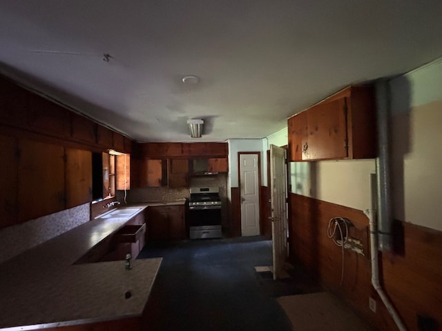 26334 Fm 2090th Rd, Splendora, TX 77372 - kitchen with stainless steel range, wood walls, and brown cabinetry