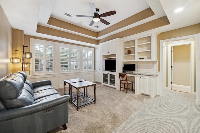 59 N Berryline Cir, Spring, TX 77381 - living room featuring a ceiling fan, a raised ceiling, built in study area, and light carpet