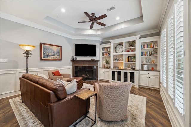 59 N Berryline Cir, Spring, TX 77381 - living area featuring ceiling fan, a tray ceiling, dark wood-style flooring, a fireplace, and crown molding
