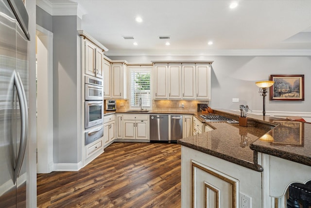 59 N Berryline Cir, Spring, TX 77381 - kitchen with appliances with stainless steel finishes, a warming drawer, cream cabinetry, crown molding, and a peninsula