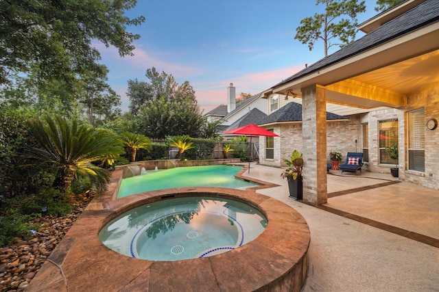 59 N Berryline Cir, Spring, TX 77381 - pool at dusk featuring a patio and a pool with connected hot tub