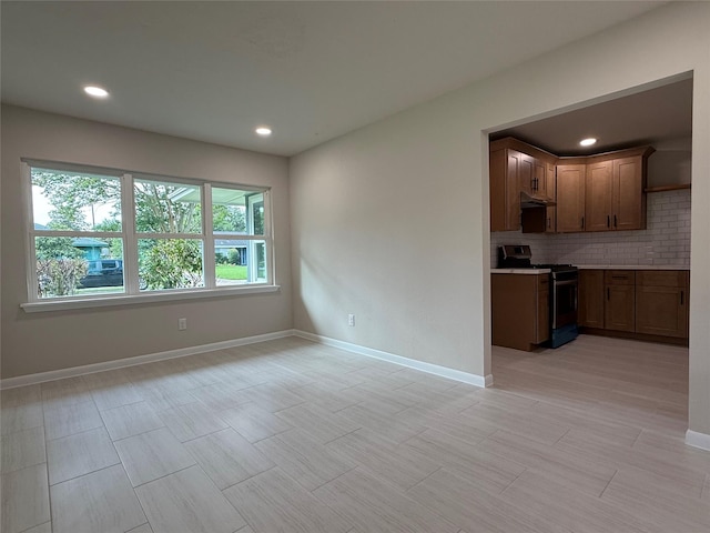 6202 Simsdale St, Houston, TX 77087 - kitchen featuring stainless steel range with electric cooktop, tasteful backsplash, light countertops, under cabinet range hood, and recessed lighting