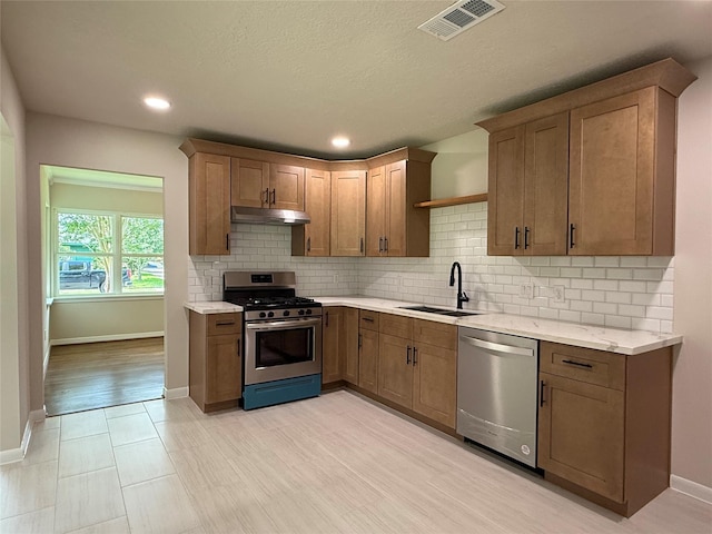 6202 Simsdale St, Houston, TX 77087 - kitchen with appliances with stainless steel finishes, under cabinet range hood, tasteful backsplash, recessed lighting, and light stone countertops