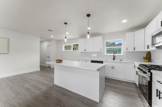 200 Burnett Dr, Baytown, TX 77520 - kitchen featuring appliances with stainless steel finishes, a kitchen island, light wood-type flooring, healthy amount of natural light, and recessed lighting