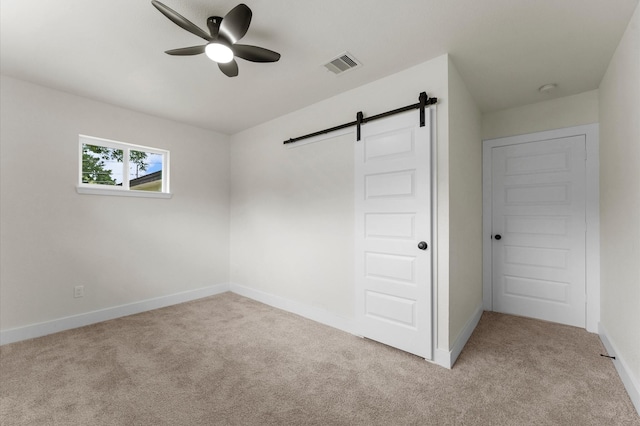200 Burnett Dr, Baytown, TX 77520 - unfurnished bedroom featuring a barn door, carpet flooring, and a ceiling fan
