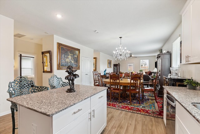 23502 Glenbuck St, Spring, TX 77373 - kitchen with light wood-style floors, dishwasher, a chandelier, a breakfast bar, and plenty of natural light