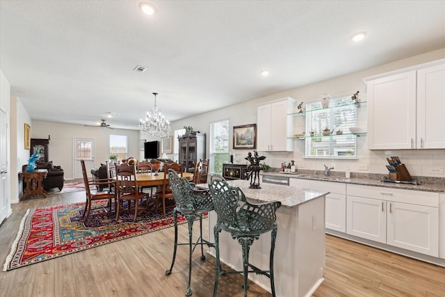 23502 Glenbuck St, Spring, TX 77373 - kitchen with a chandelier, open floor plan, a breakfast bar area, light wood-type flooring, and recessed lighting