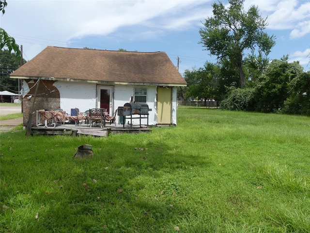 7713 Airline Dr, Houston, TX 77037 - rear view of house featuring a lawn, roof with shingles, and an outbuilding