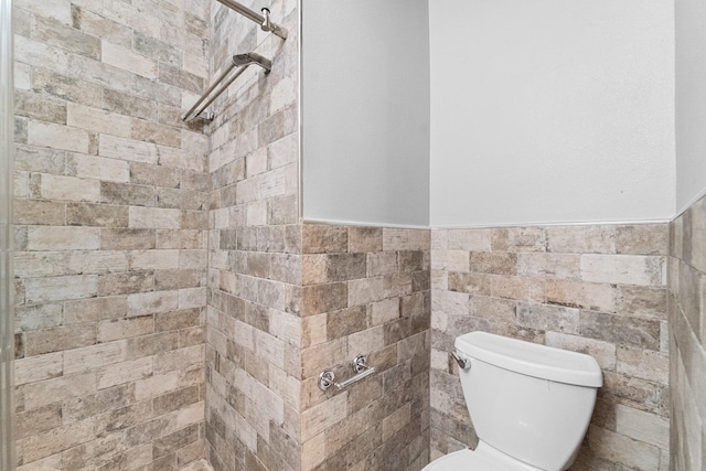 18203 Park Sage Ct, Cypress, TX 77433 - bathroom with a wainscoted wall, tiled shower, and tile walls
