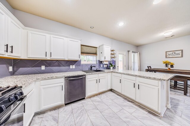 10627 Fire Sage Dr, Humble, TX 77396 - kitchen with stainless steel dishwasher, gas stove, light marble finish flooring, white cabinets, and a peninsula