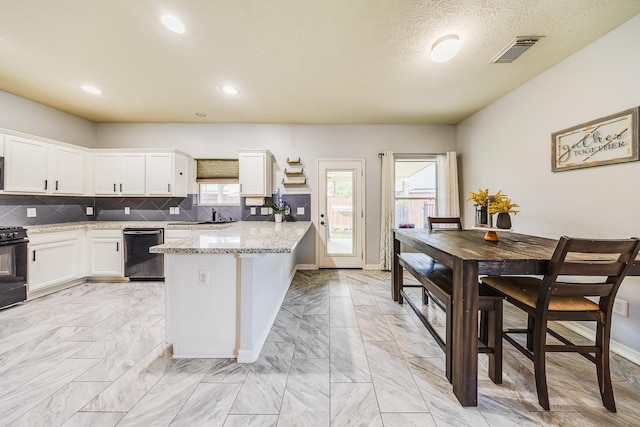10627 Fire Sage Dr, Humble, TX 77396 - kitchen featuring dishwashing machine, light marble finish floors, a peninsula, white cabinets, and decorative backsplash