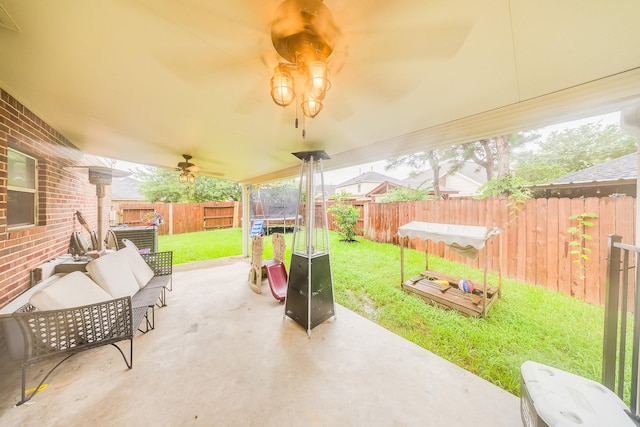 10627 Fire Sage Dr, Humble, TX 77396 - fenced backyard with a trampoline, a patio area, and ceiling fan