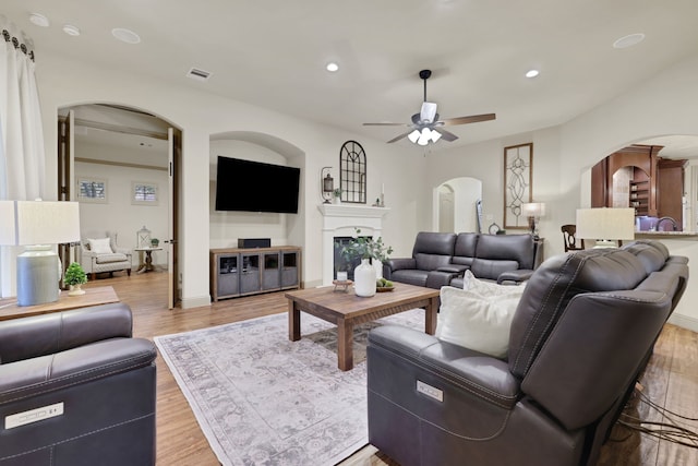 21311 Fairhaven Meadow Dr, Cypress, TX 77433 - living area featuring arched walkways, a ceiling fan, wood finished floors, recessed lighting, and a fireplace