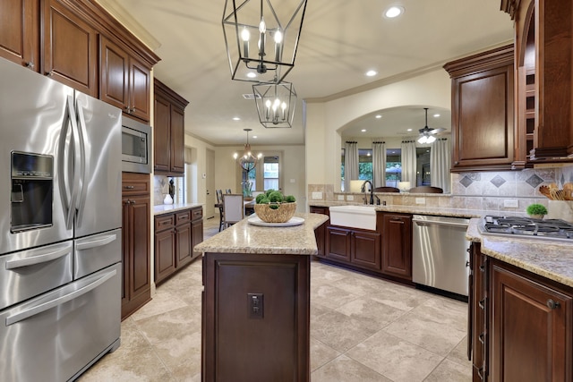 21311 Fairhaven Meadow Dr, Cypress, TX 77433 - kitchen with appliances with stainless steel finishes, a chandelier, a kitchen island, backsplash, and crown molding