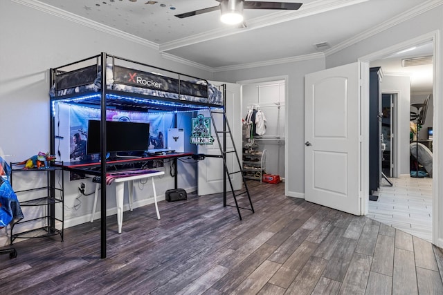 902 51st St, Galveston, TX 77551 - bedroom featuring wood finished floors, ornamental molding, a ceiling fan, and a walk in closet