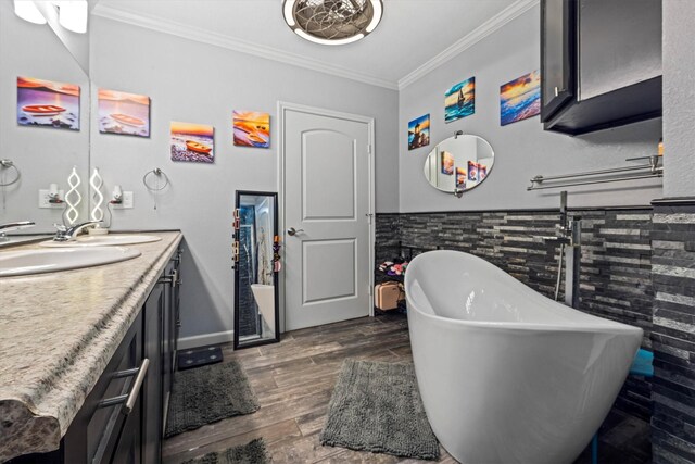 902 51st St, Galveston, TX 77551 - bathroom with vanity, crown molding, a freestanding tub, wood finished floors, and a wainscoted wall