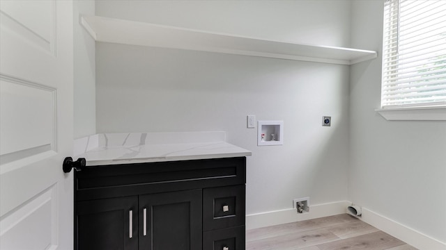 6902 Apollo St, Houston, TX 77091 - washroom featuring hookup for an electric dryer, washer hookup, light wood finished floors, and cabinet space