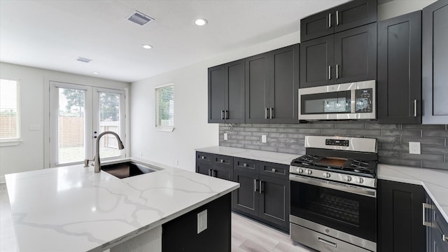 6902 Apollo St, Houston, TX 77091 - kitchen with appliances with stainless steel finishes, recessed lighting, decorative backsplash, light stone countertops, and dark cabinets