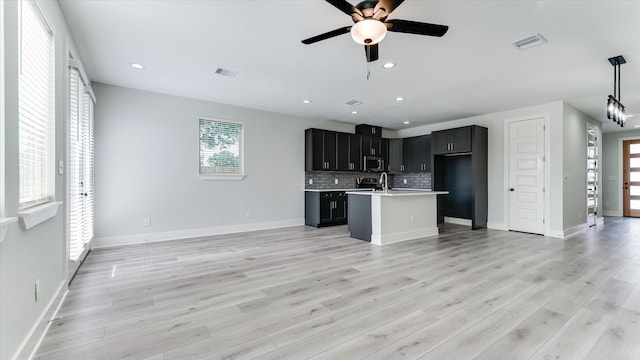 6902 Apollo St, Houston, TX 77091 - kitchen featuring stainless steel microwave, open floor plan, healthy amount of natural light, ceiling fan, and recessed lighting