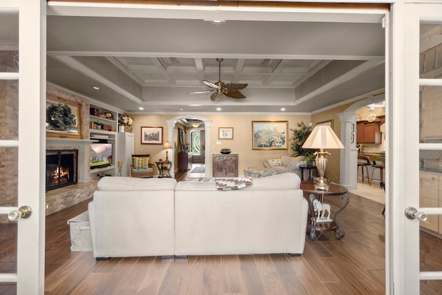 13306 Boca Raton Dr, Houston, TX 77069 - living area with ornamental molding, arched walkways, a ceiling fan, decorative columns, and a fireplace