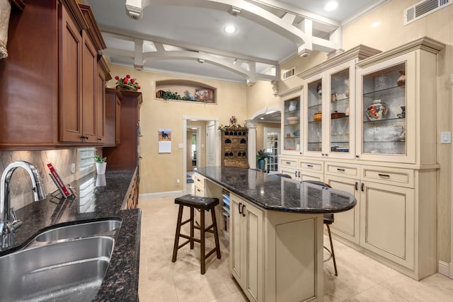 13306 Boca Raton Dr, Houston, TX 77069 - kitchen with cream cabinets, a kitchen breakfast bar, ornamental molding, glass insert cabinets, and dark stone counters