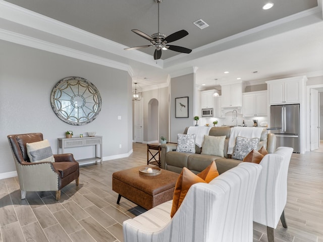 103 Lakeshore Ct, Clute, TX 77531 - living room with a tray ceiling, arched walkways, recessed lighting, ceiling fan, and ornamental molding