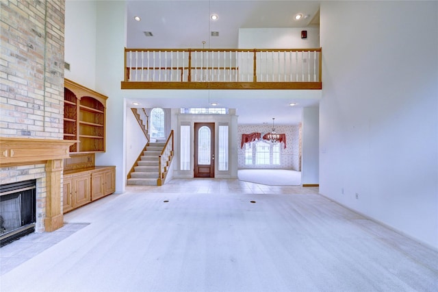 3134 Lake Island Dr, Montgomery, TX 77356 - unfurnished living room featuring a towering ceiling, a fireplace, a chandelier, and stairway