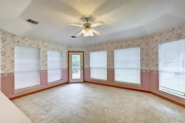3134 Lake Island Dr, Montgomery, TX 77356 - spare room with wallpapered walls, ceiling fan, and a textured ceiling