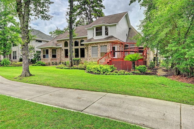 3134 Lake Island Dr, Montgomery, TX 77356 - view of front facade with brick siding, a deck, a front lawn, and roof with shingles