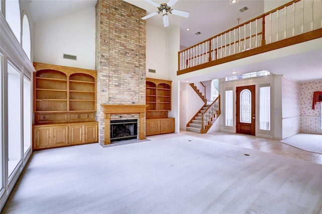 3134 Lake Island Dr, Montgomery, TX 77356 - unfurnished living room featuring a towering ceiling, plenty of natural light, a brick fireplace, ceiling fan, and carpet