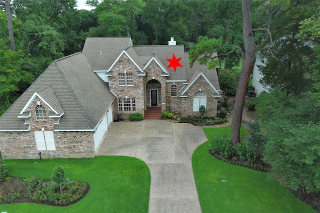 3134 Lake Island Dr, Montgomery, TX 77356 - view of front facade featuring stone siding, driveway, roof with shingles, and a front yard