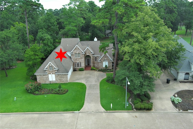 3134 Lake Island Dr, Montgomery, TX 77356 - view of front of house featuring stone siding, concrete driveway, a front yard, and a chimney