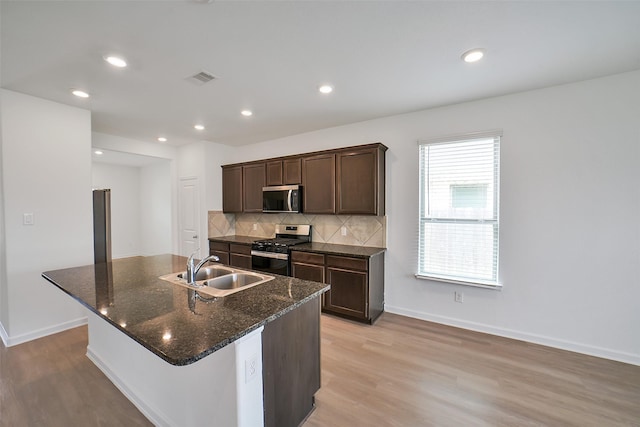 4918 Eldorado Rose Pl, Katy, TX 77493 - kitchen with stainless steel appliances, light wood-style floors, backsplash, dark brown cabinetry, and recessed lighting