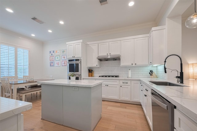 14439 Basalt Ln, Houston, TX 77077 - kitchen with stainless steel appliances, ornamental molding, light stone counters, backsplash, and white cabinetry