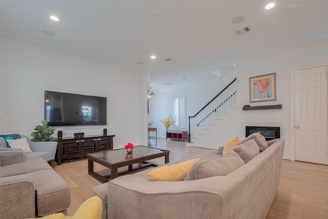 14439 Basalt Ln, Houston, TX 77077 - living area with crown molding, light wood-type flooring, stairs, a glass covered fireplace, and recessed lighting