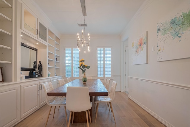 14439 Basalt Ln, Houston, TX 77077 - dining area featuring light wood-style floors, a chandelier, crown molding, and built in shelves
