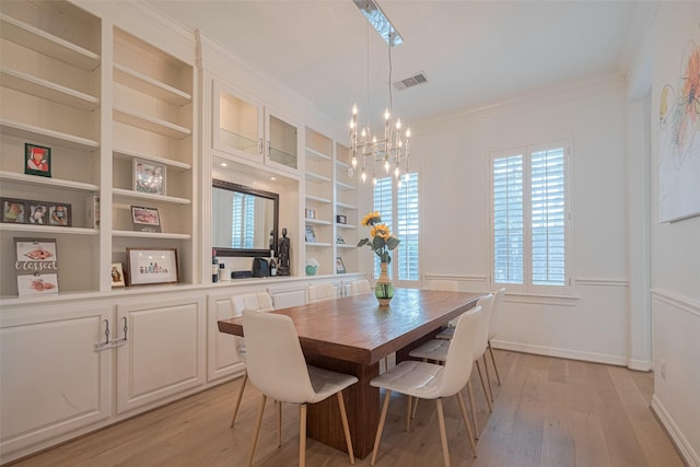 14439 Basalt Ln, Houston, TX 77077 - dining space featuring a chandelier, built in features, light wood finished floors, and ornamental molding