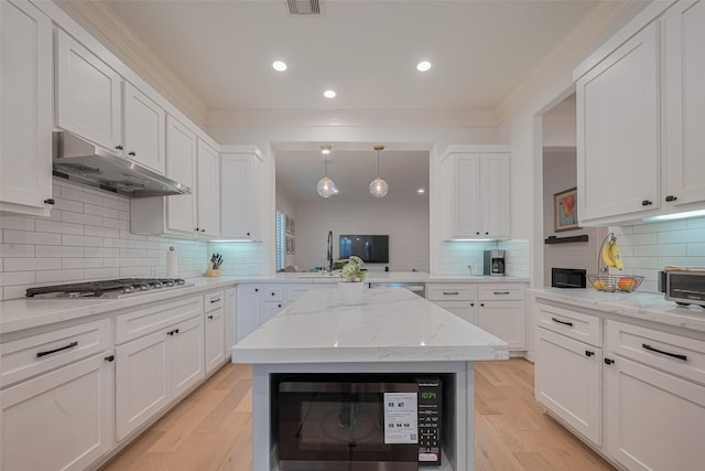 14439 Basalt Ln, Houston, TX 77077 - kitchen with under cabinet range hood, appliances with stainless steel finishes, white cabinets, backsplash, and crown molding